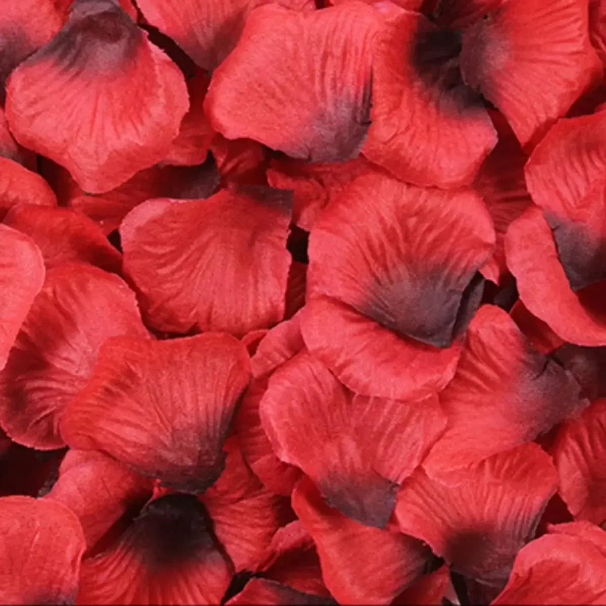 A close-up of deep red and dark purple silk rose petals for weddings and events.