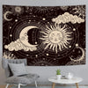 A dark tapestry wall hanging featuring a celestial design with a crescent moon and a sun surrounded by stars and clouds.