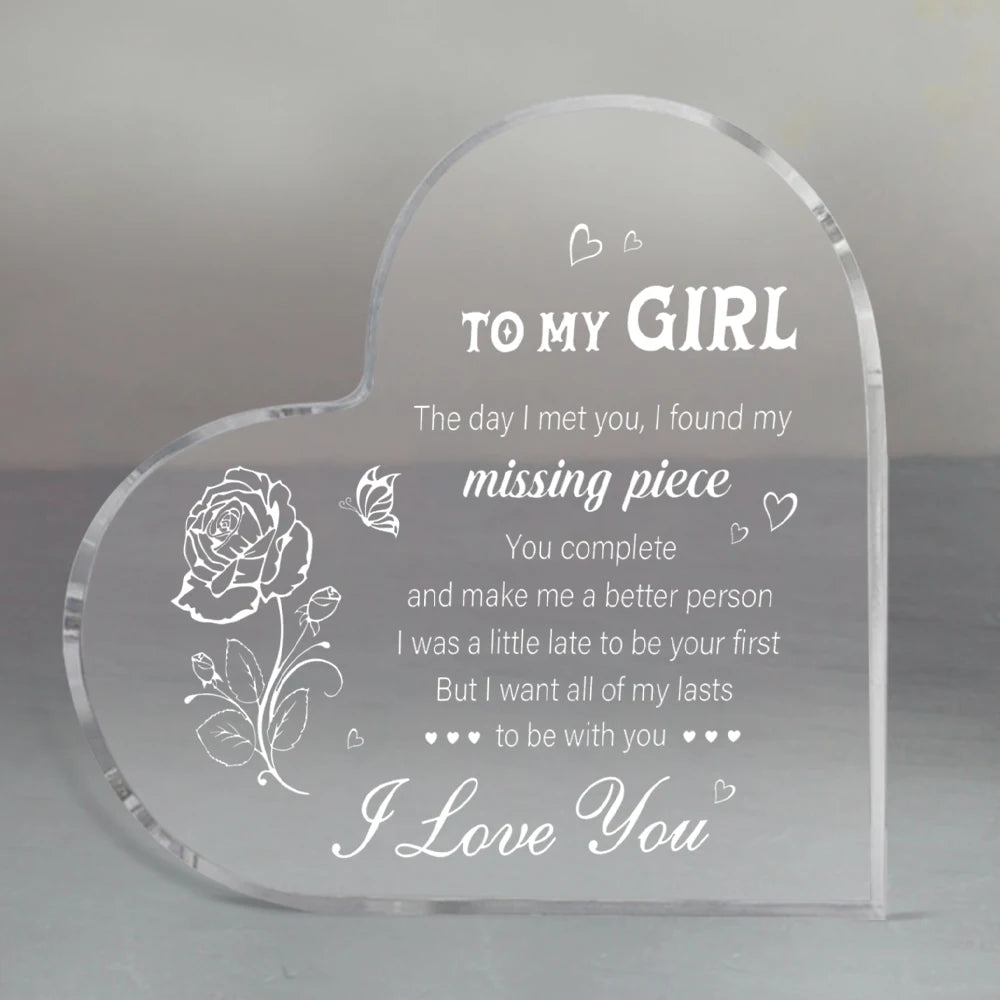 A clear heart-shaped acrylic keepsake engraved with a message to a girl and a rose design.