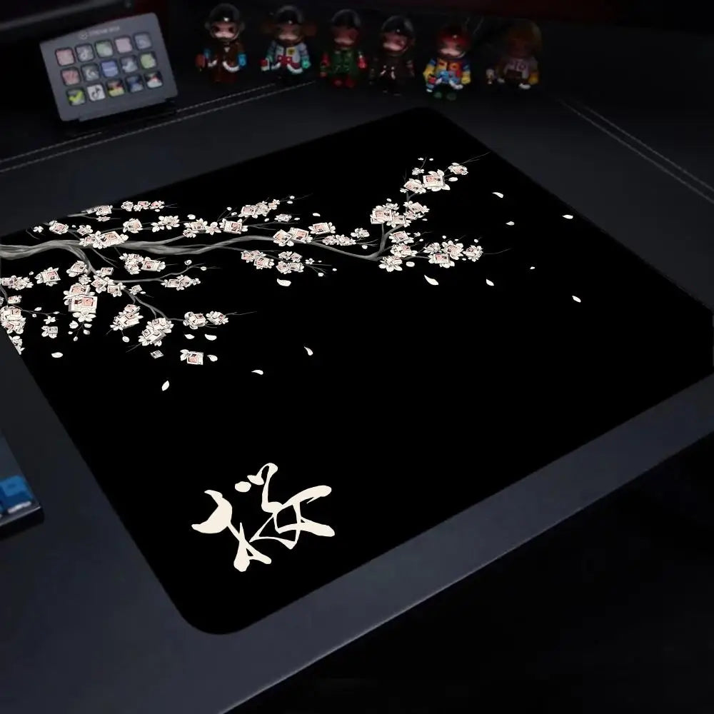 A black gaming mouse pad featuring a delicate white cherry blossom branch design.