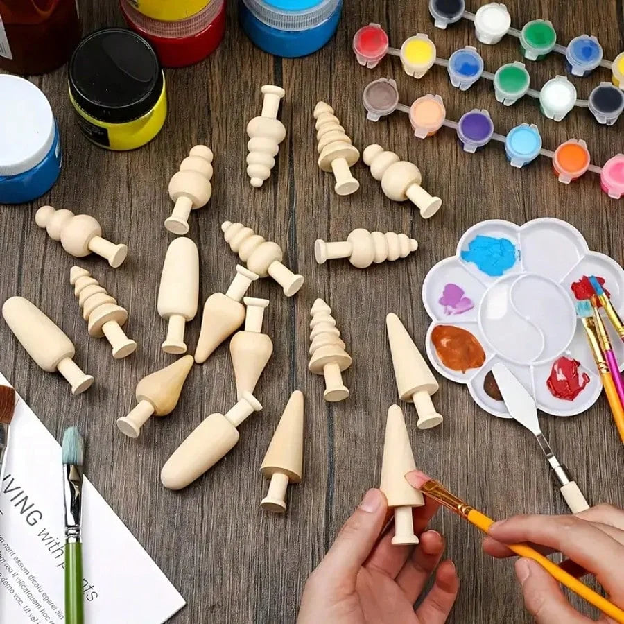 A collection of wooden DIY ornaments and paintbrushes arranged on a dark wooden surface.