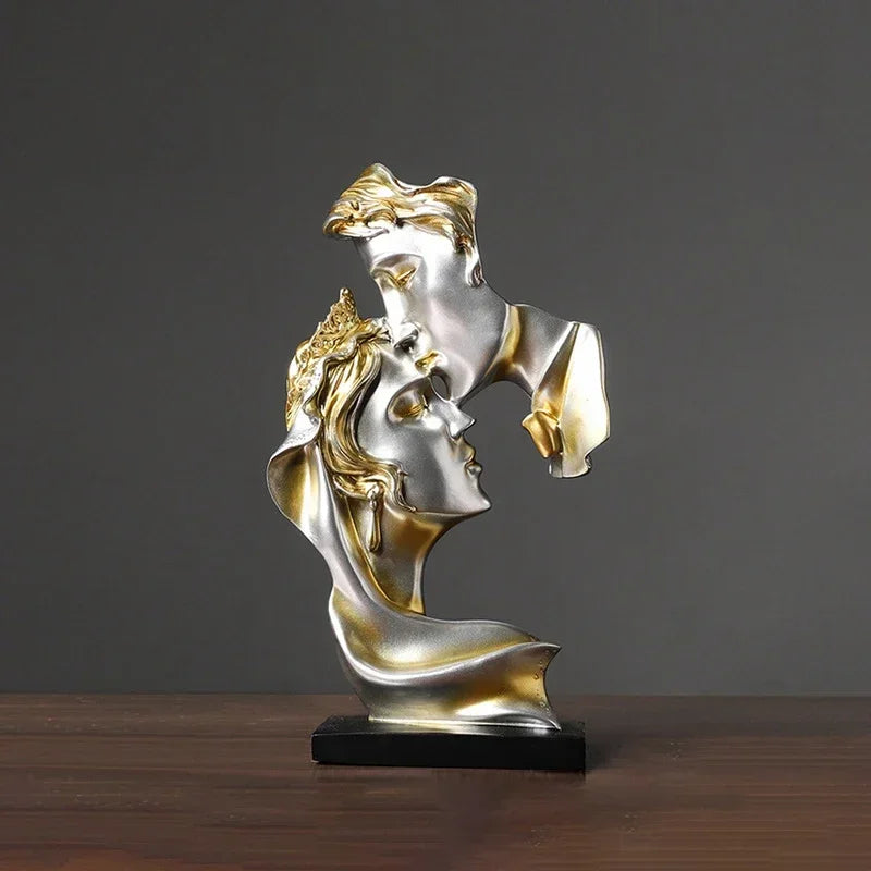 Statue en résine argent et or représentant deux profils d'amants s'étreignant.