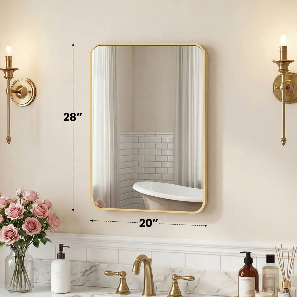 A modern wall mirror with a gold metal frame reflects a white bathtub and tiled wall in a bathroom setting.