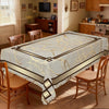 A beige tablecloth with a black and gold marble stripe pattern is displayed on a wooden dining table.