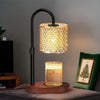A black adjustable heat candle warmer lamp with a textured glass shade and a candle on a wooden base.