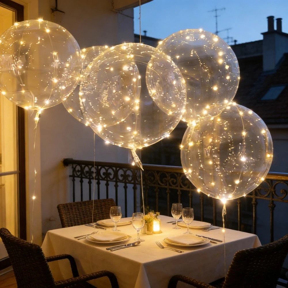 A cluster of glowing LED illuminated party balloons floating above a table at dusk.