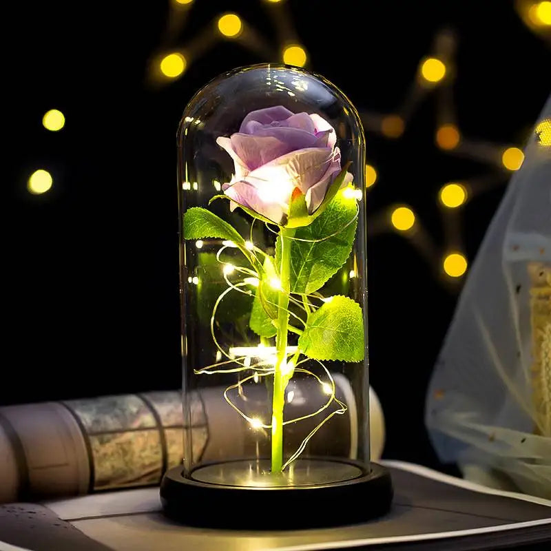 An eternal rose LED light simulation flower is displayed in a glass tube with glowing wires against a dark background.