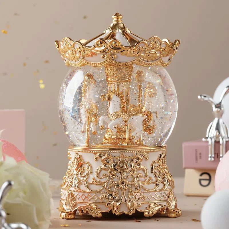 Adorno de caja de música con bola de cristal dorada y blanca, detallado, sobre una base decorativa.