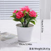 A potted artificial bonsai tree decoration with vibrant pink flowers set against a white background.