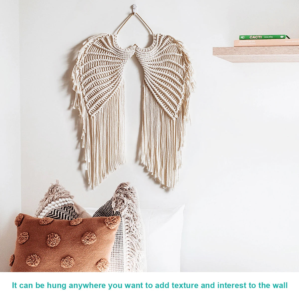 Handwoven angel wing macrame wall hanging made of natural beige fibers displayed on a white wall.