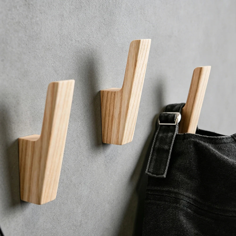 Naturholz-Wandhaken an einer grauen Wand, zum Aufhängen von Mäppchen, Taschen und Handtüchern.