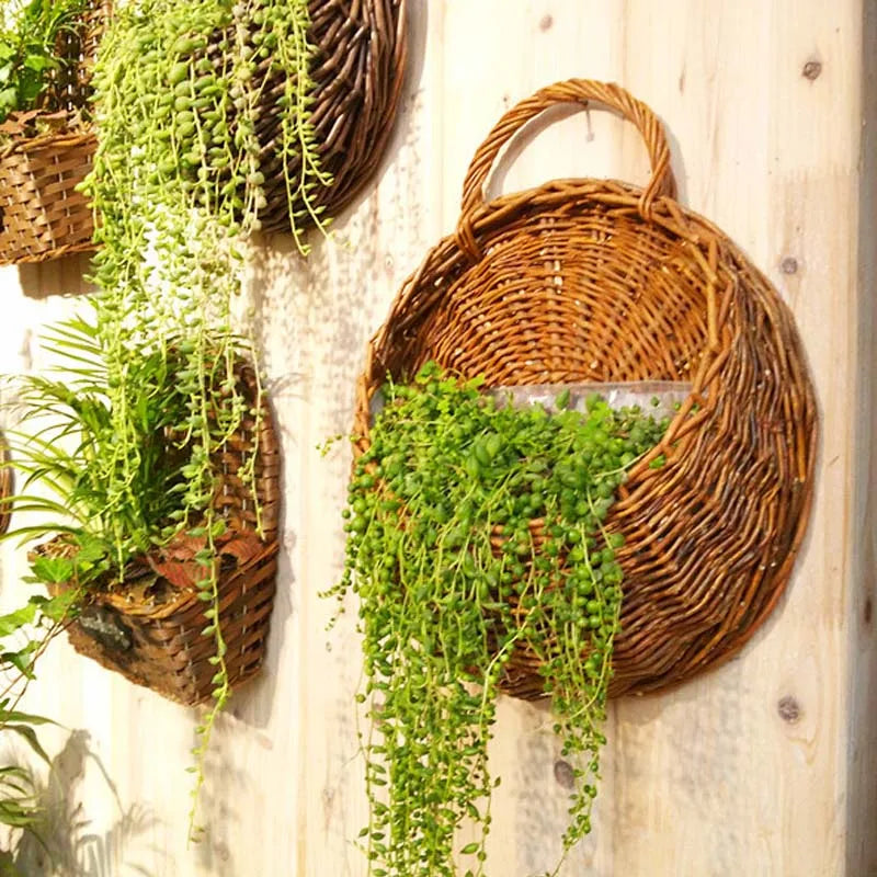 A woven basket wall hanging featuring lush green artificial plant vines.
