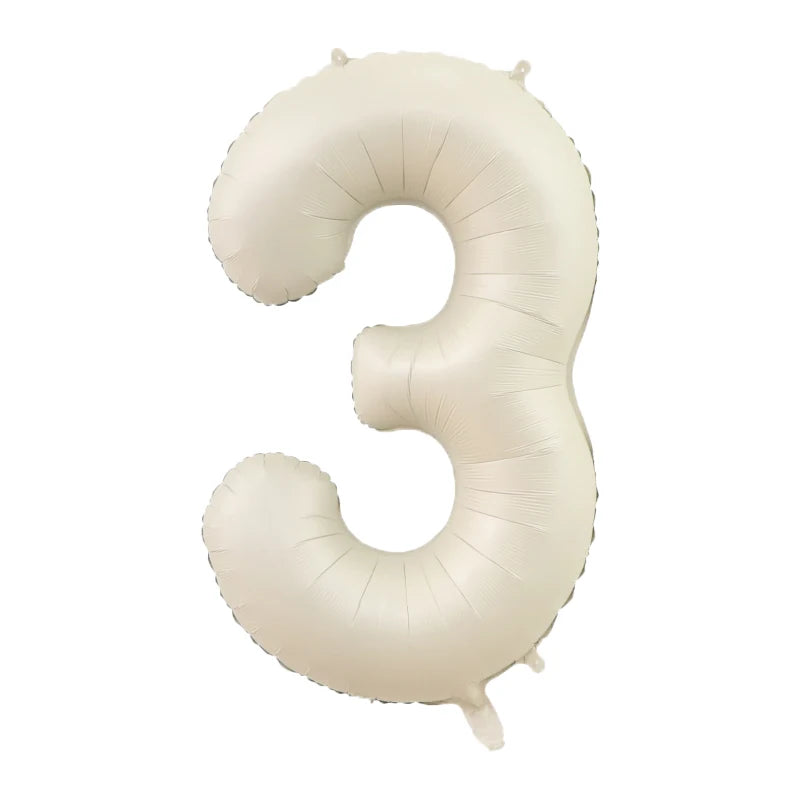 A large, beige foil number balloon shaped like the number three.