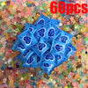 A pile of sixty glow-in-the-dark fairy garden resin figurine bags in various shades of blue and purple on a colorful backgrou