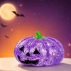 Purple Halloween pumpkin stress ball with a carved face against a dark purple background.