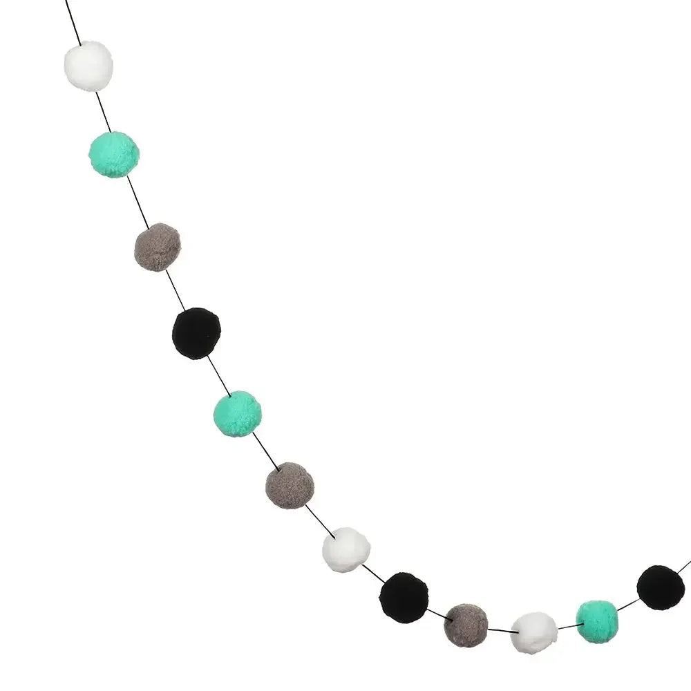 A garland of colorful felt balls in shades of white, teal, and gray.