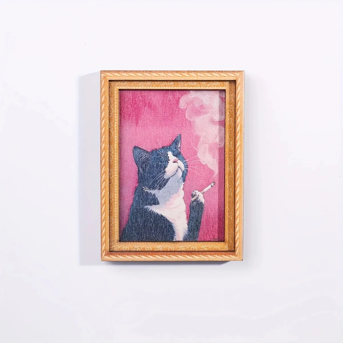 A framed painting of a black and white cat smoking a cigarette against a pink background.