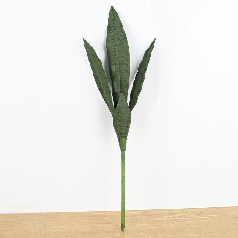 Una planta artificial de snake alta y verde con hojas erguidas, exhibida contra un fondo blanco.