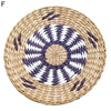Round woven straw wall decor hanging with a concentric pattern of white and dark gray stripes.
