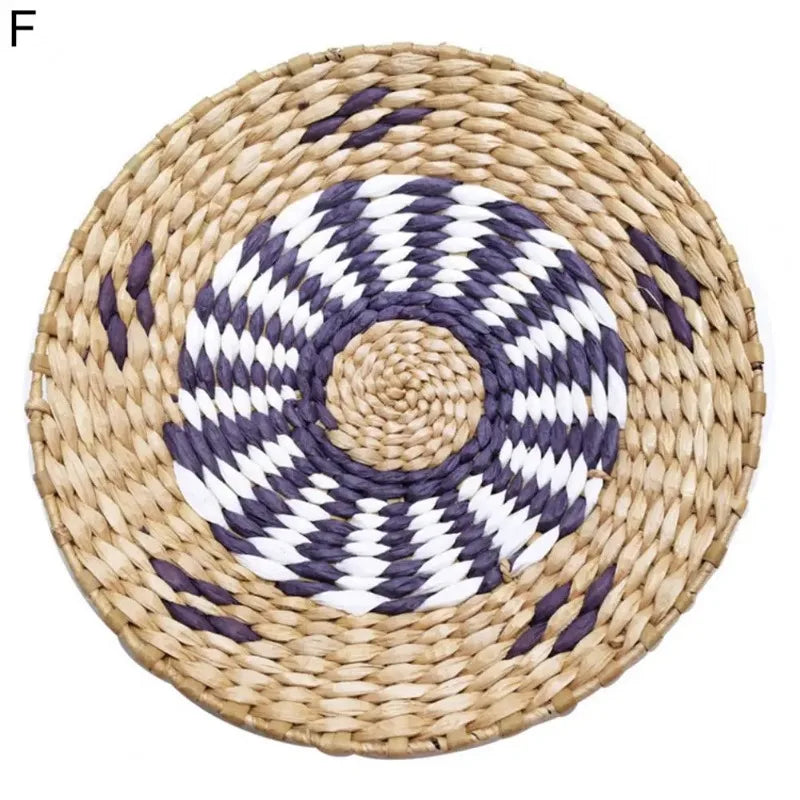Round woven straw wall decor hanging with a concentric pattern of white and dark gray stripes.