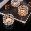 A set of romantic crystal tealight candle lantern holders with intricate glasswork displayed on a dark surface.