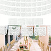 White Mexican fiesta cutout banners hanging above a long table setting for a party or Dia de Muertos event