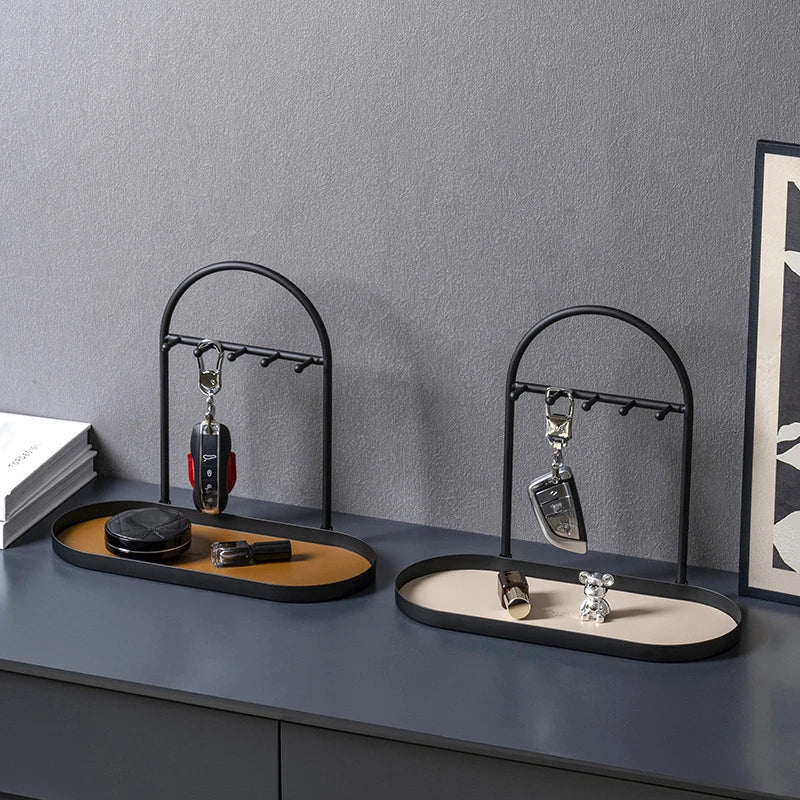A black wrought iron desk organizer rack holding various leather and metal accessories like pens and cufflinks.