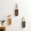 A set of handcrafted wooden wall-mounted hydroponic plant vases displaying dried floral arrangements.