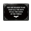 A black metal tin sign with white gothic text that reads You are dearer to me than all the bats in all the caves in the world