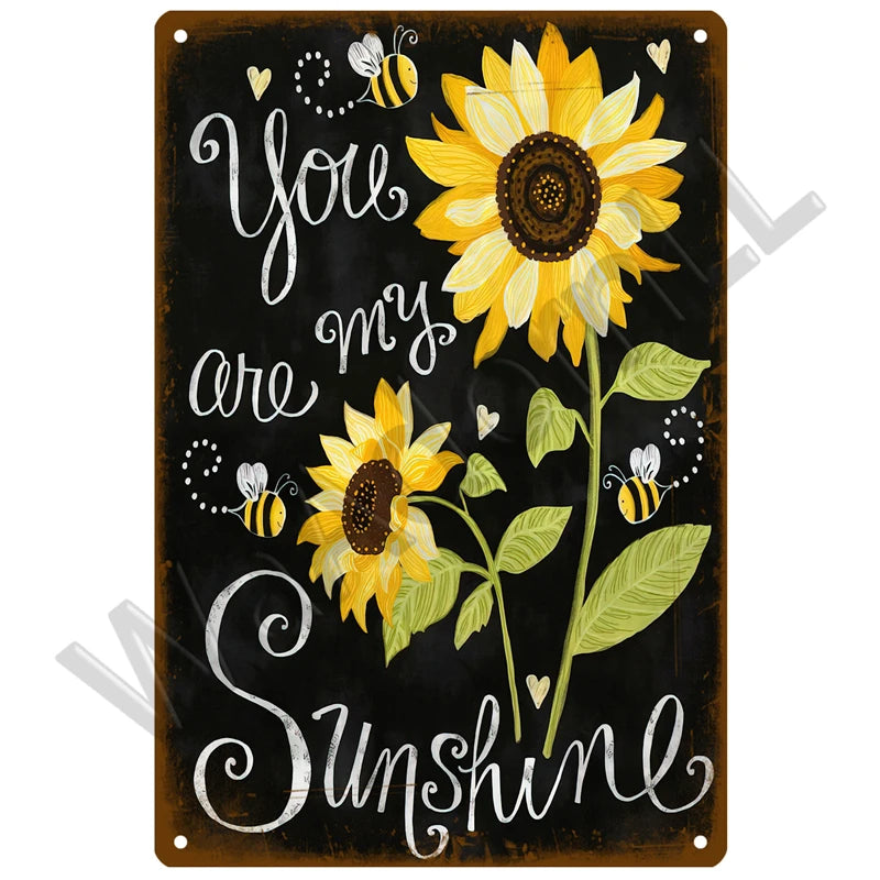 A dark metal sign with white script and yellow sunflower illustrations, featuring the text You are my Sunshine.