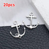 20 pieces of silver vintage ship anchor charms for jewelry making displayed on a dark surface.