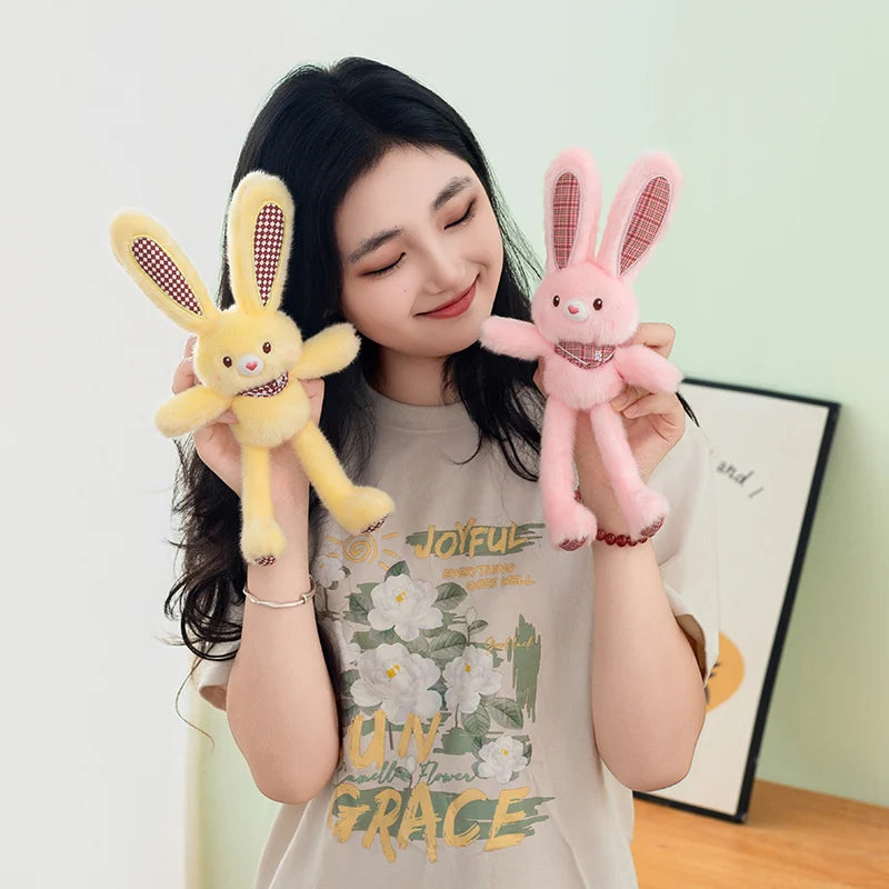 A woman holds a pink rabbit plush toy with pink ears and a checkered pattern against a light green background.