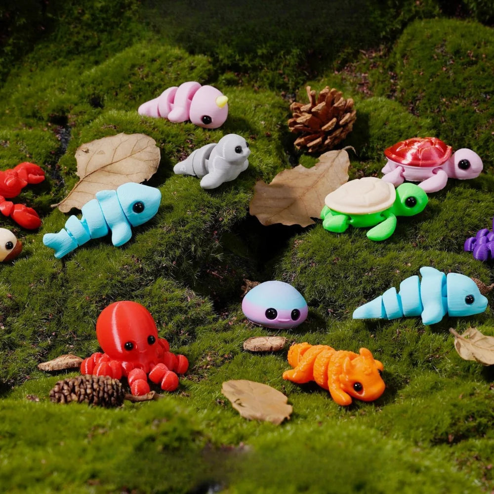 A collection of colorful, small marine animal figurines like turtles and fish scattered on green moss.