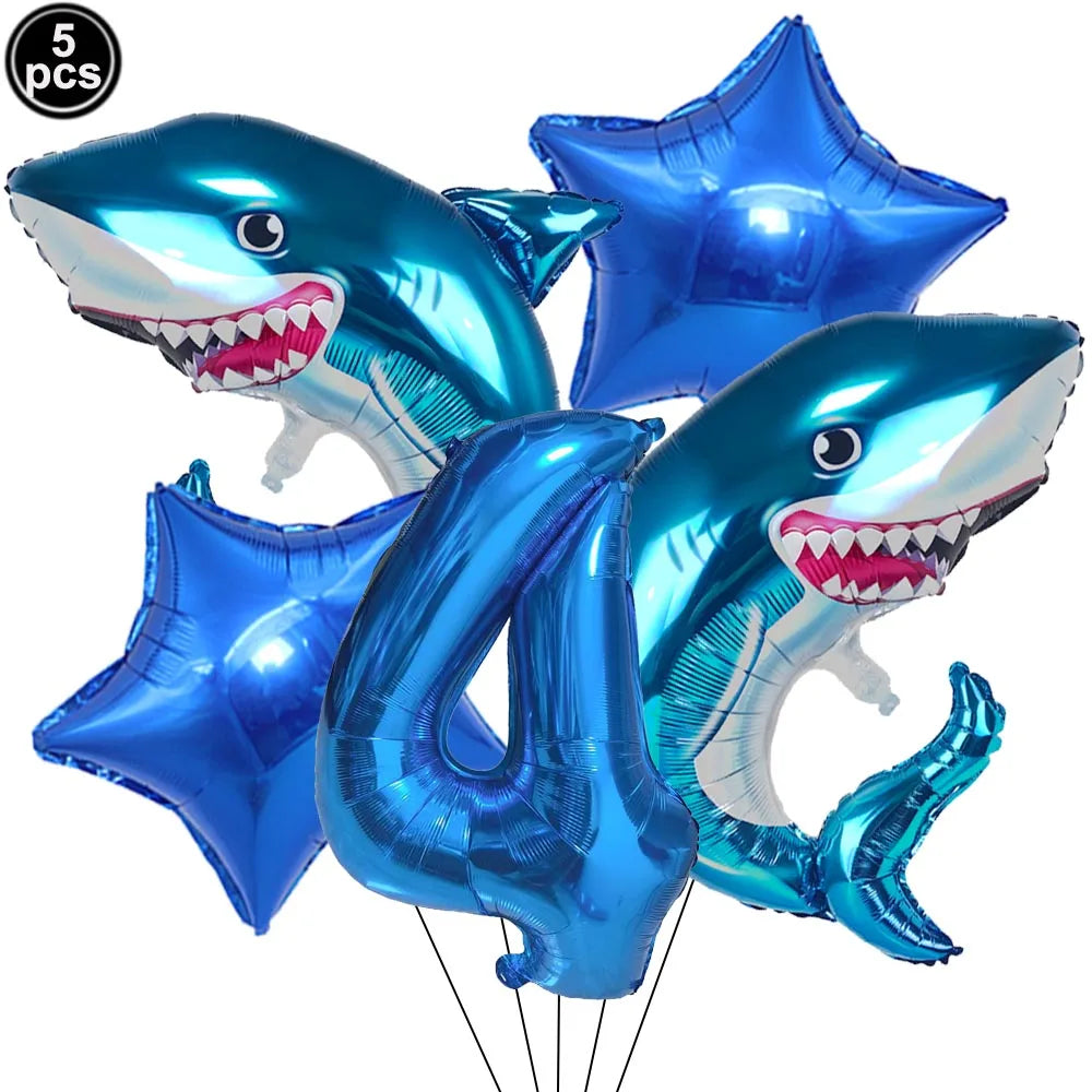 A blue shark foil balloon decoration with a toothy smile, used for an ocean-themed party.