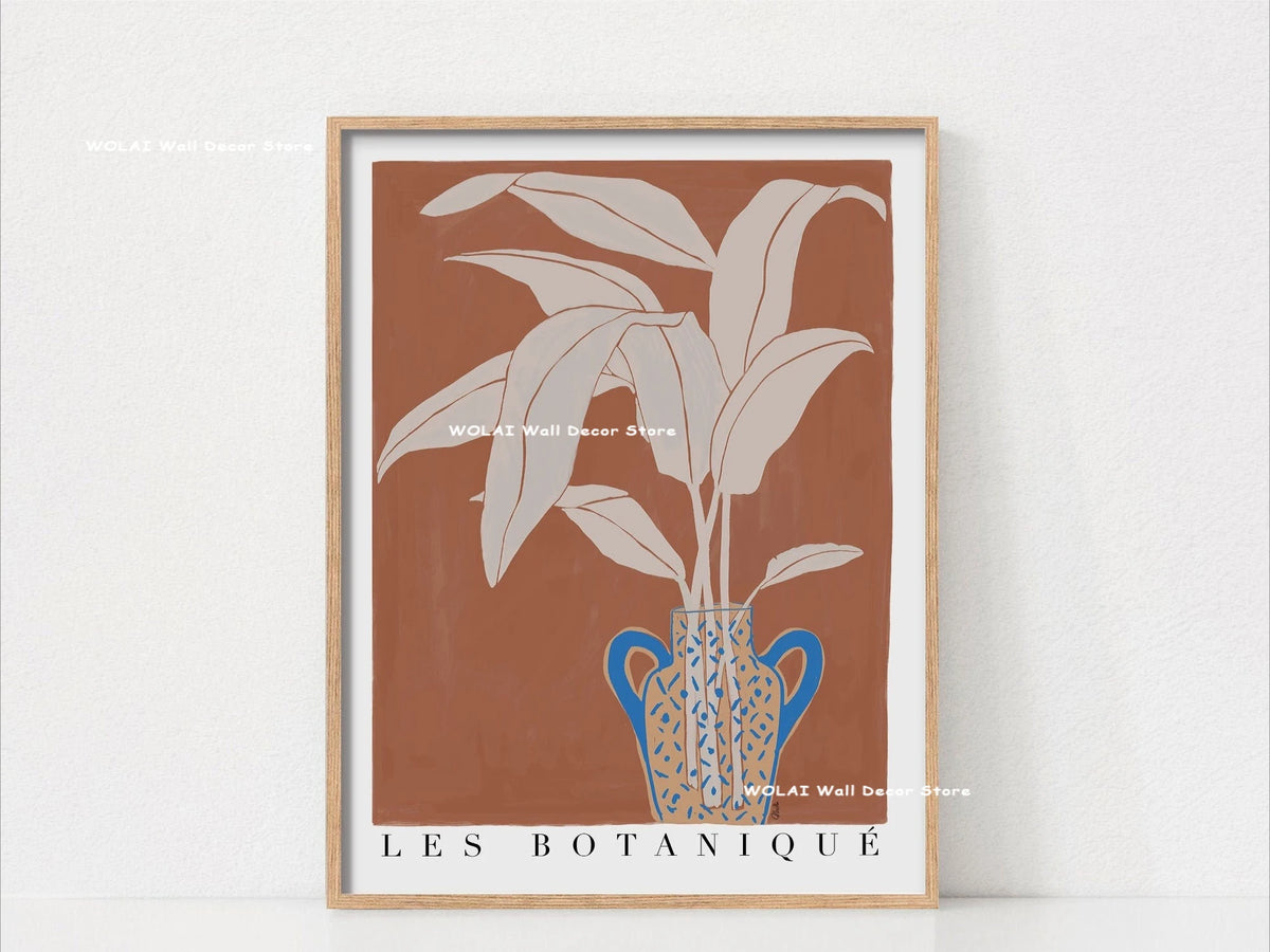 Wall art featuring a potted philodendron plant in a blue ceramic vase against a terracotta background.