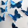 A collection of twelve iridescent blue mirror effect butterfly wall stickers scattered on a white background.