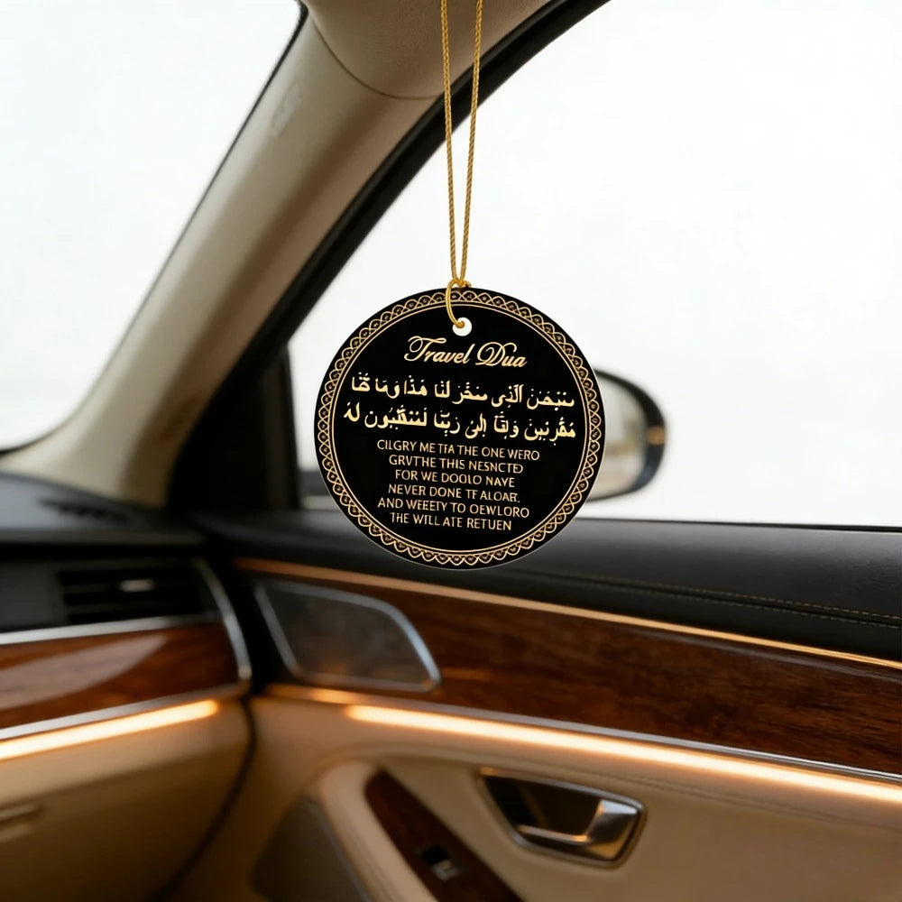 A round gold-colored tag with black text featuring Arabic and English prayer phrases hanging from a thin gold chain inside a 