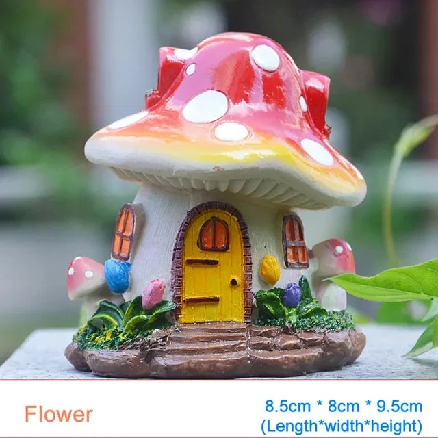 A small resin mushroom house garden statue with a yellow door and red cap and white spots.