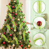 Christmas tree decorated with feather-like branches, red berries, and sparkling red balls.