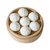A set of white steamer buns and dumplings arranged in a wooden tray for fridge magnets.