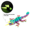 A colorful, translucent chameleon fidget toy with glowing horns and eyes against a dark background.