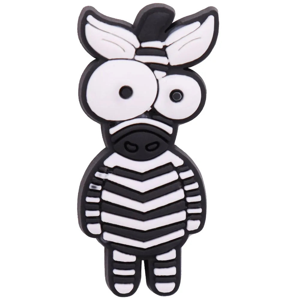 A set of twelve cartoon dinosaur PVC shoe charms featuring a stylized, black and white striped dinosaur face.