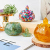 A collection of colorful crystal bowls, including a large iridescent bowl and smaller green and amber glass bowls, displayed 