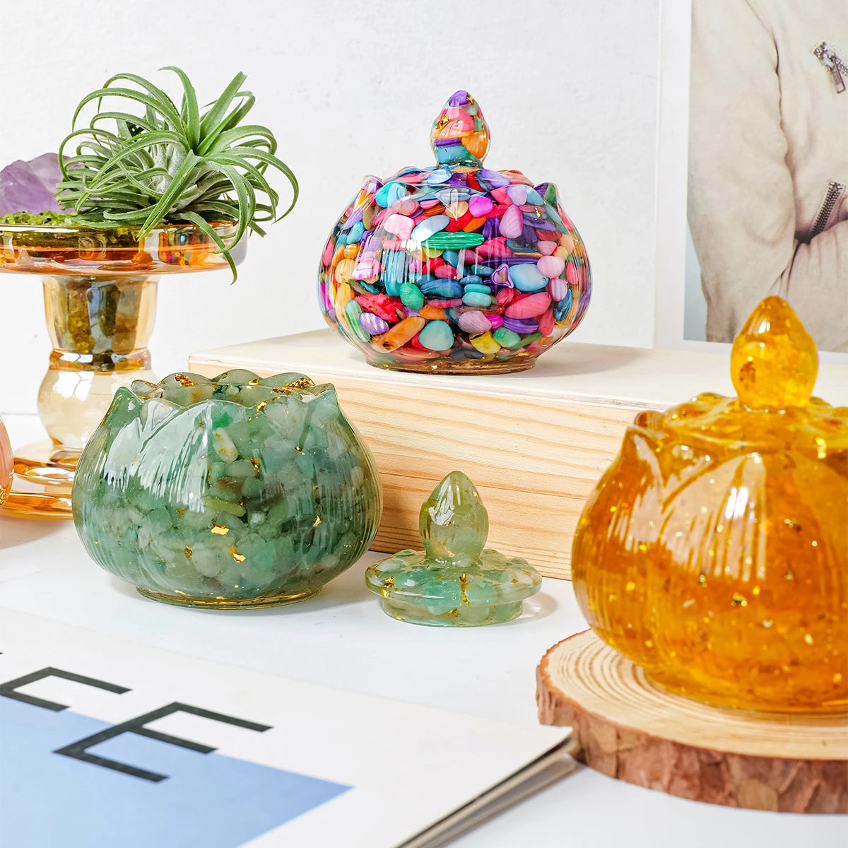 A collection of colorful crystal bowls, including a large iridescent bowl and smaller green and amber glass bowls, displayed 