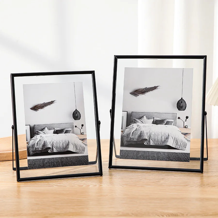 A modern black floating picture frame displaying a bedroom scene with a bed and decorative elements.