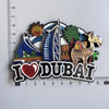 A collection of wooden fridge magnets featuring landmarks like a sail, palm tree, and camel, with the text I love DUBAI.