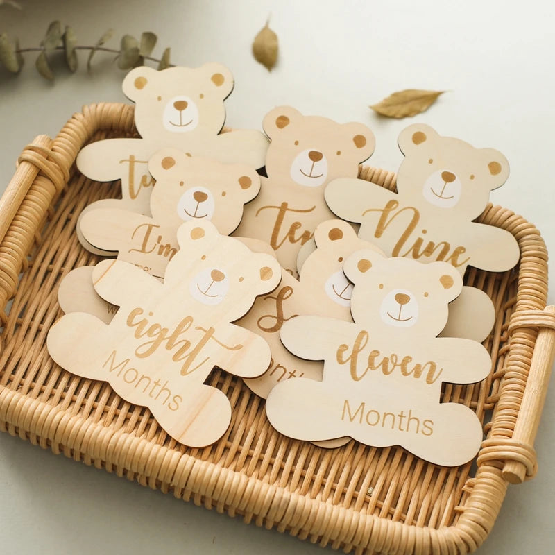 A set of wooden baby milestone cards featuring bear designs for 0 to 12 months.