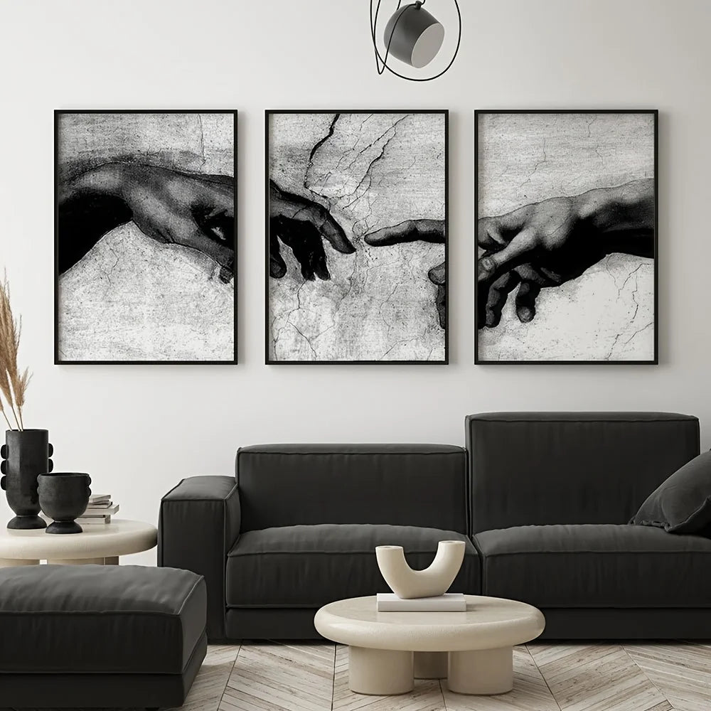 Three framed black and white canvas prints depicting hands reaching toward each other
