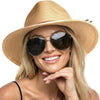 A blonde woman wearing a wide brim straw sun hat and sunglasses smiling.