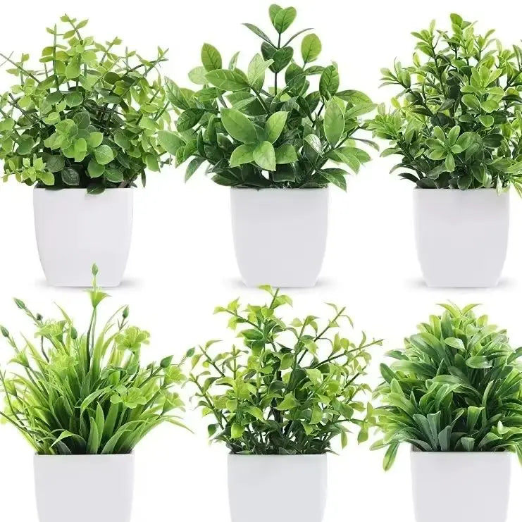 A collection of artificial bonsai plants with eucalyptus accents in white pots.